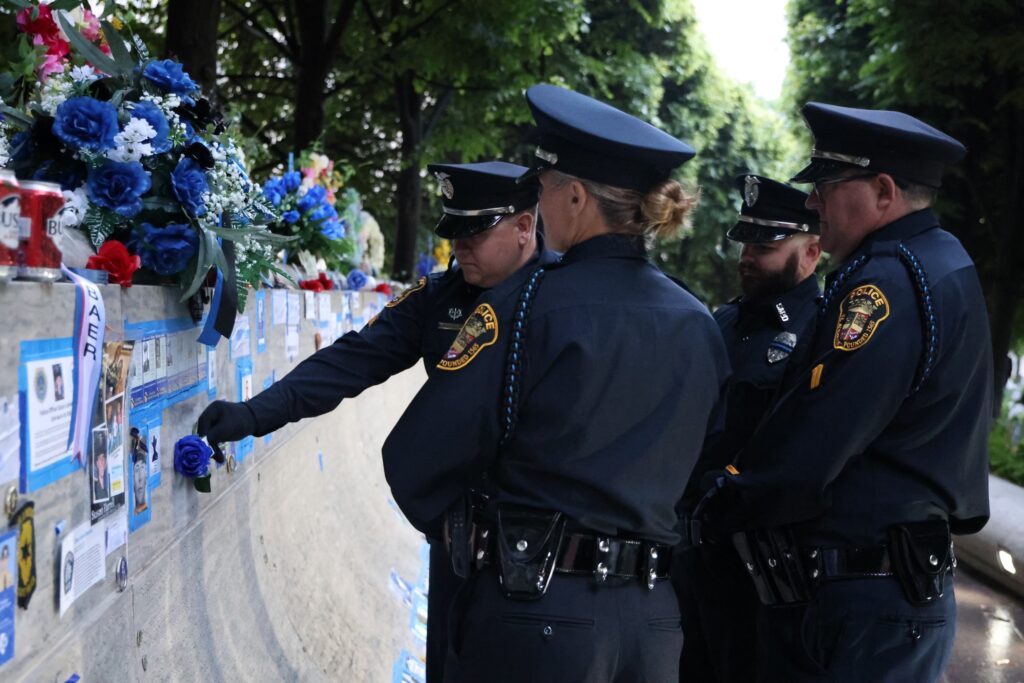 4 uniformed St. Augustine Police Officers from the honor guard team in their dress uniforms. Officers are in Washington D.C. at the National Law Enforcement Memorial Wall.